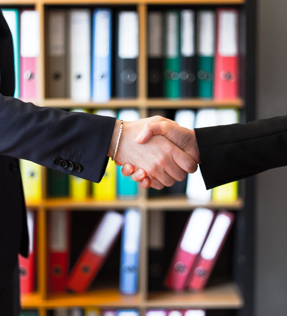 Vertrauensvoller Handschlag zwischen Berater und Mandant im Büro